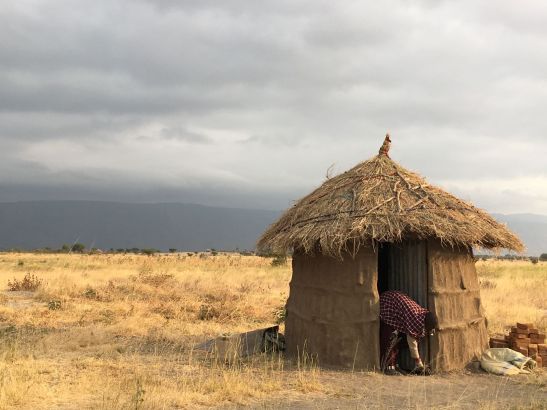 maasai vrouw aan hutje
